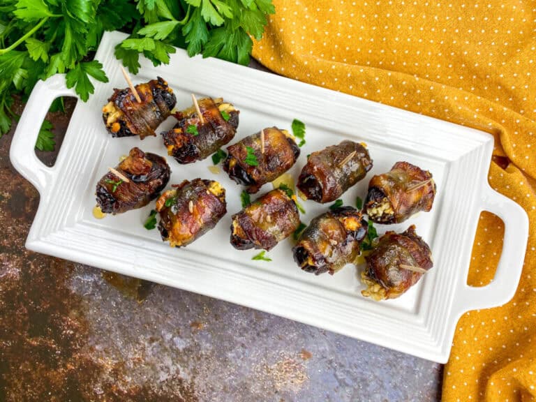 A picture of a platter of ten bacon wrapped dates.