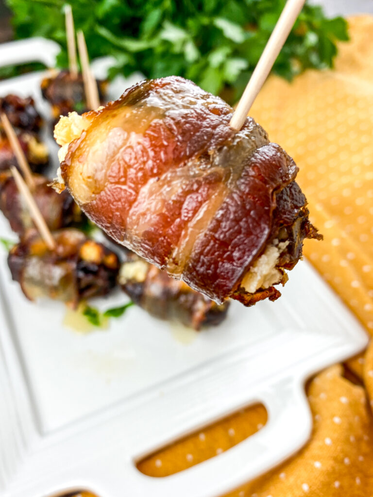 A zoomed in picture of a single bacon wrapped date.