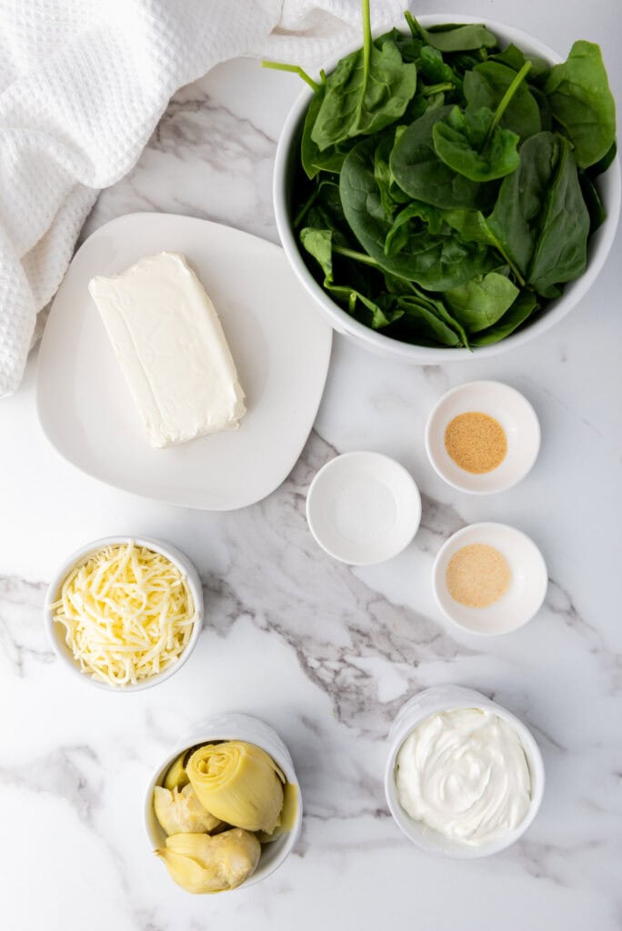 A picture of ingredients needed to make spinach artichoke dip.