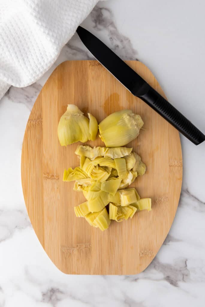 A picture of artichokes chopped on a cutting board.