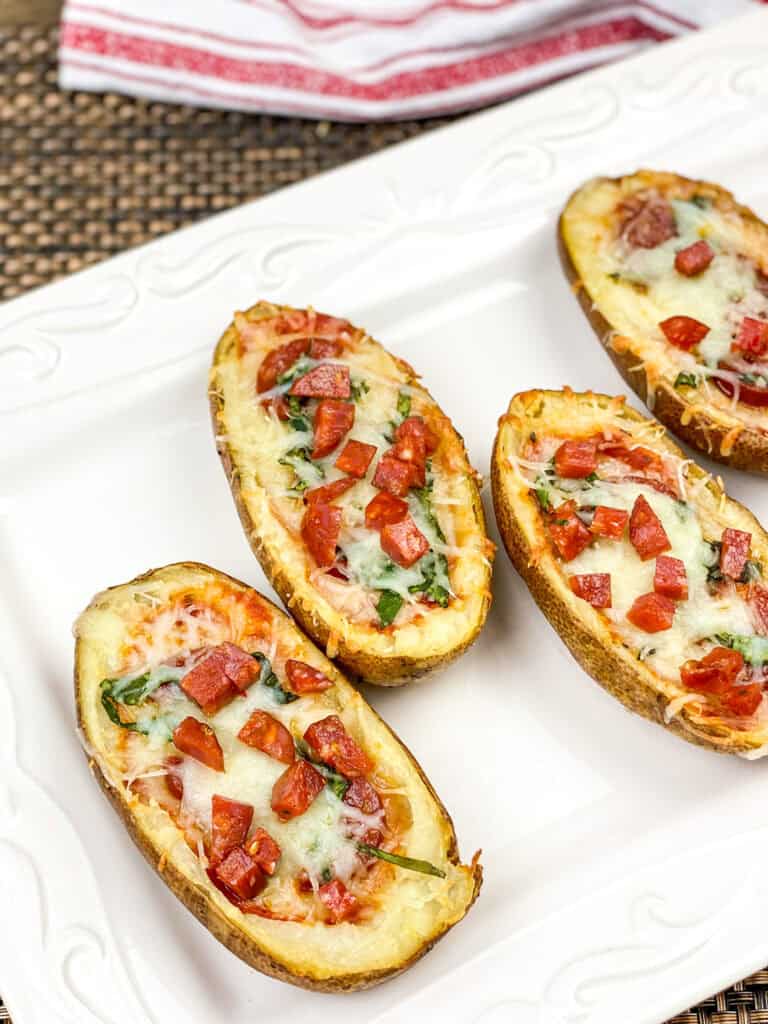 A picture of four pizza stuffed baked potato skins.