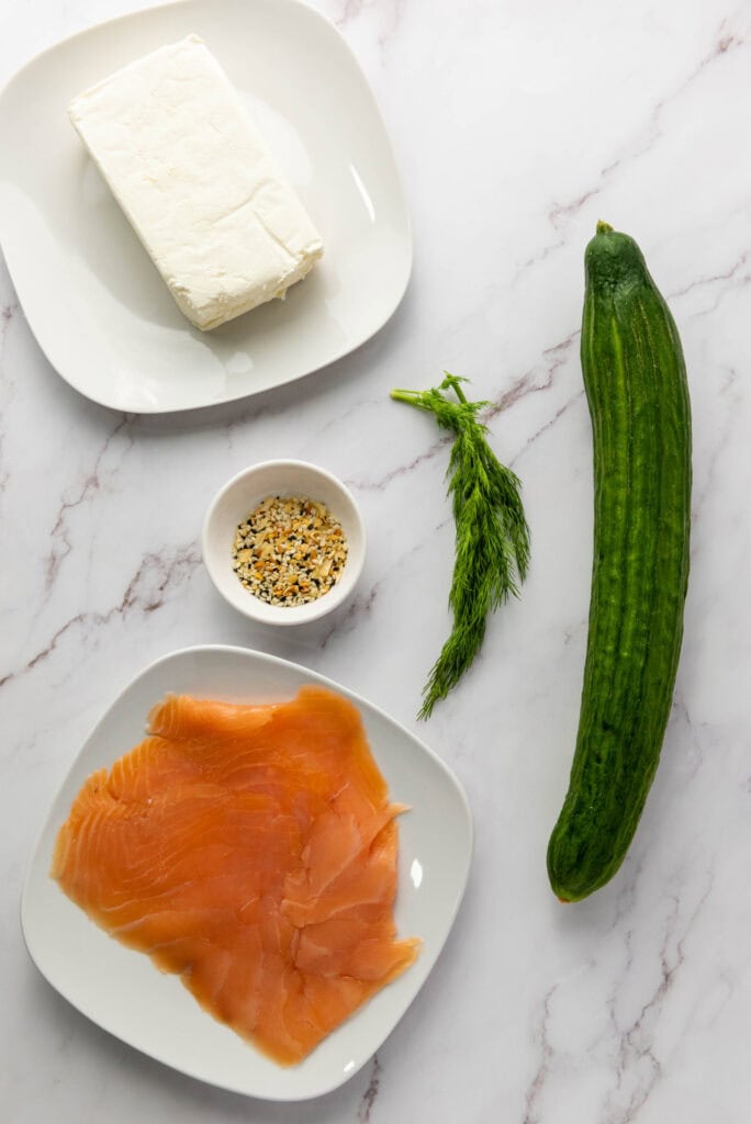 A picture of ingredients to make everything bagel cucumber rolls.