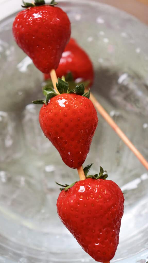 three strawberries on a skewer