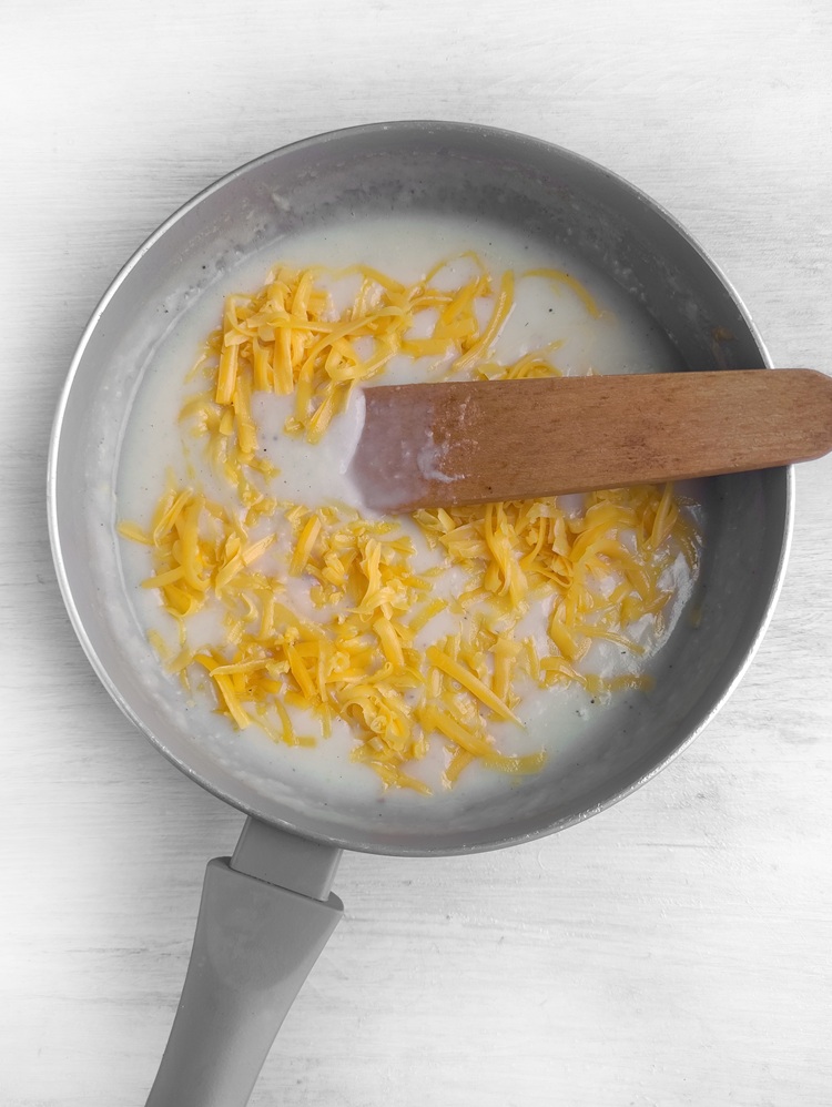 Cheese and cream boiling in a frying pan.