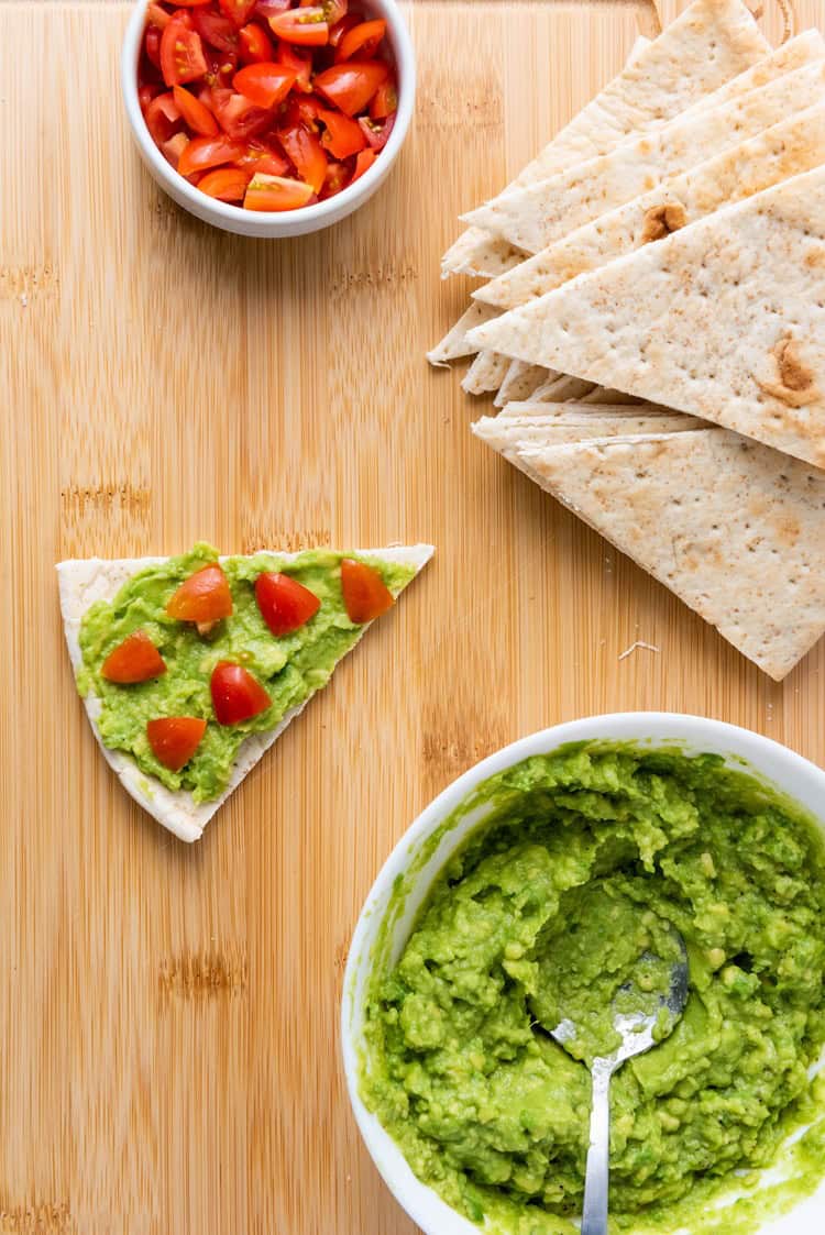 cherry tomatoes on top of avocado-smeared pita