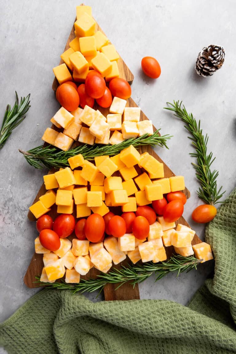 christmas tree charcuterie board with tomatoes, cheese and rosemary