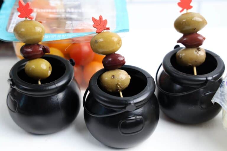 green and black olives on skewers in little black cauldrons