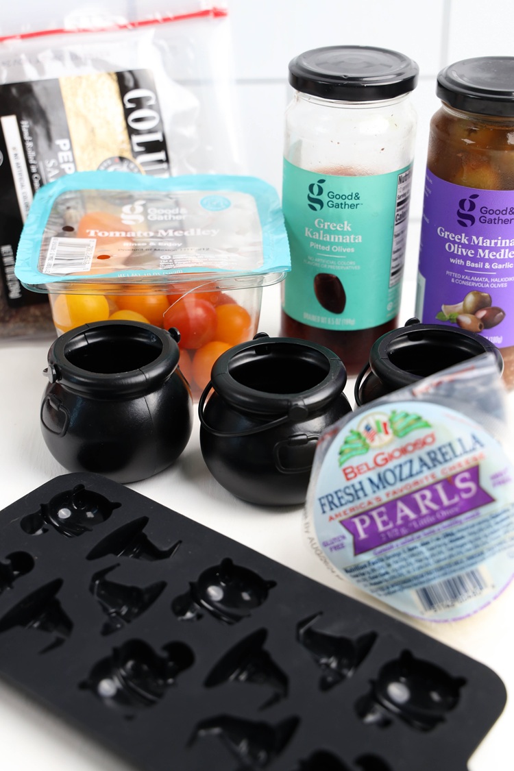 black cauldrons and other ingredients like cherry tomatoes used to make trendy halloween snack 