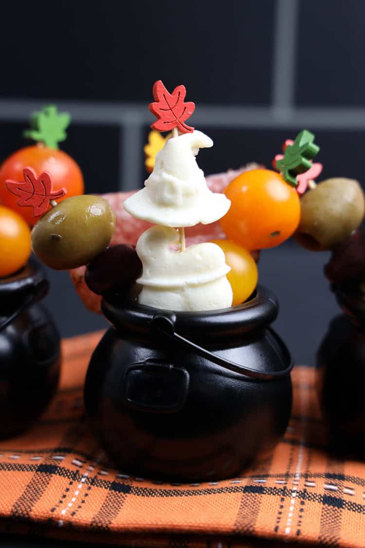 hocus pocus mini charcuterie cauldrons on an orange checkered tablecloth