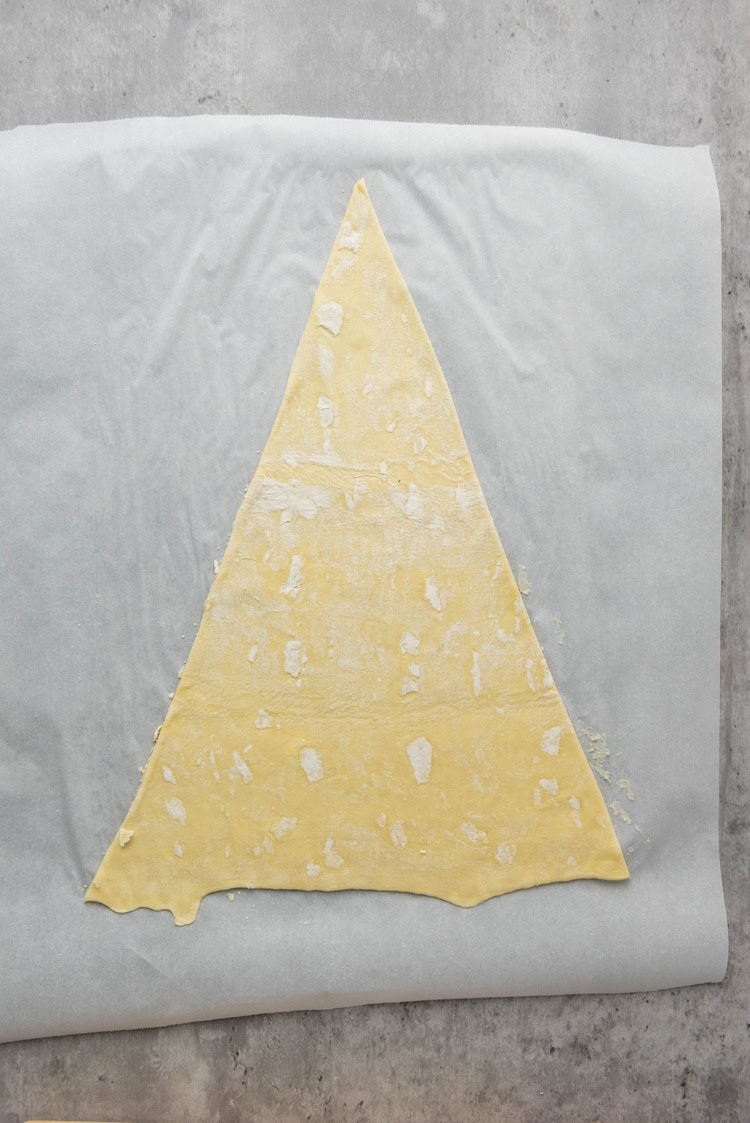 one puff pastry sheet on a pan cut into a triangle.