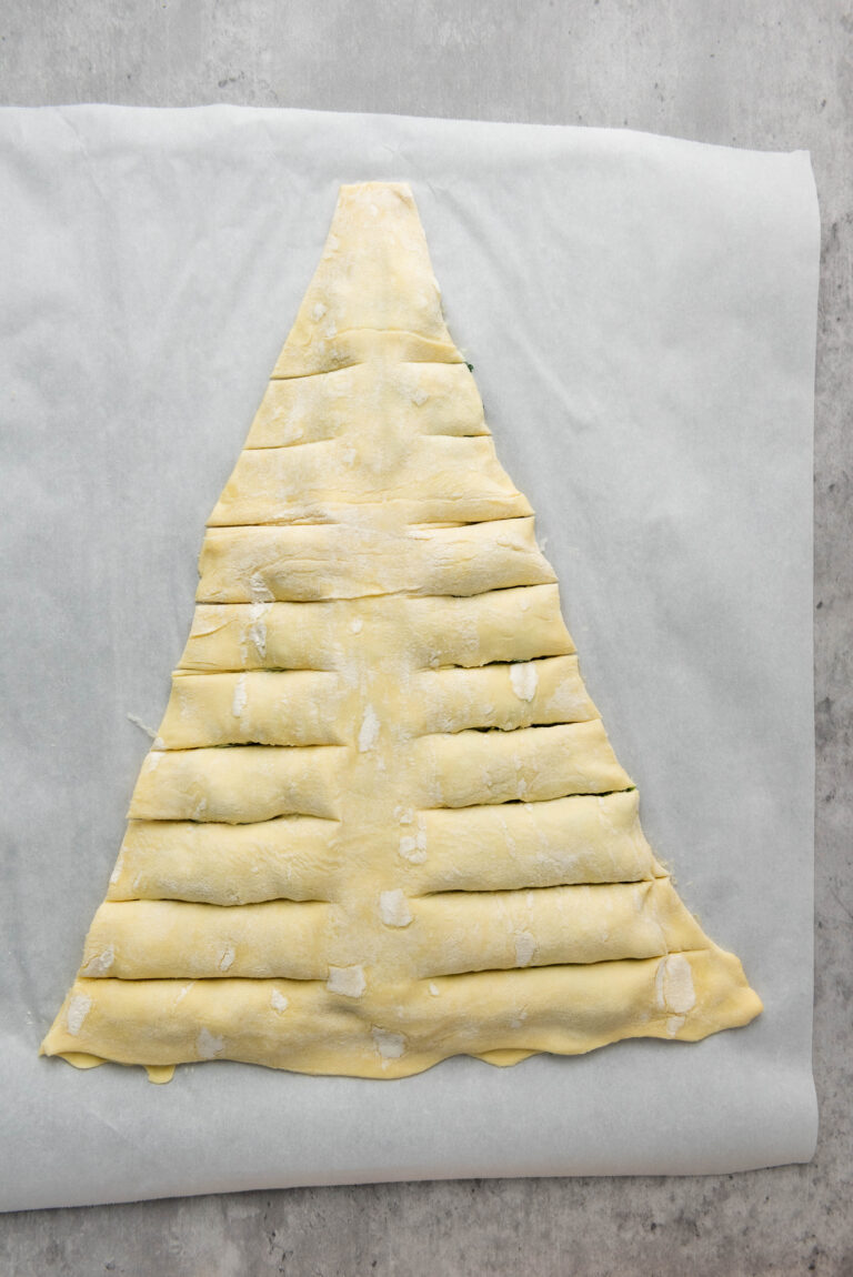 puff pastry in a triangle with horizontal strips cut on both sides