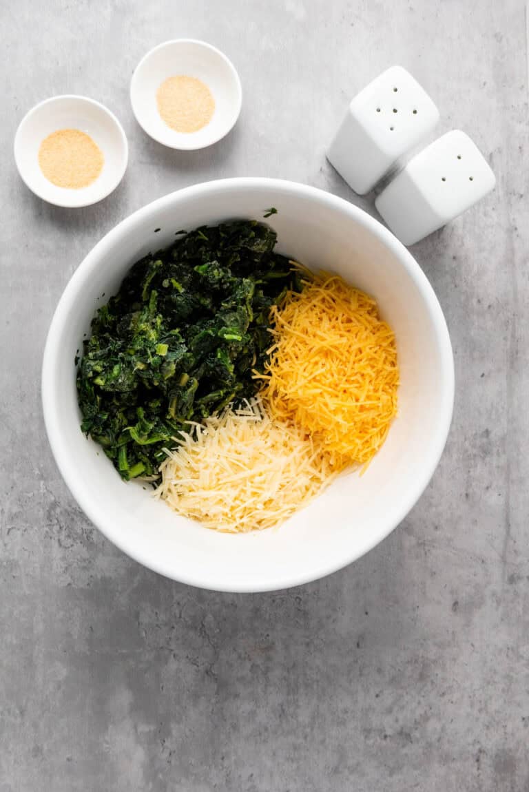 spinach, cream cheese, mozzarella, parmesan, garlic powder and other ingredients in a bowl