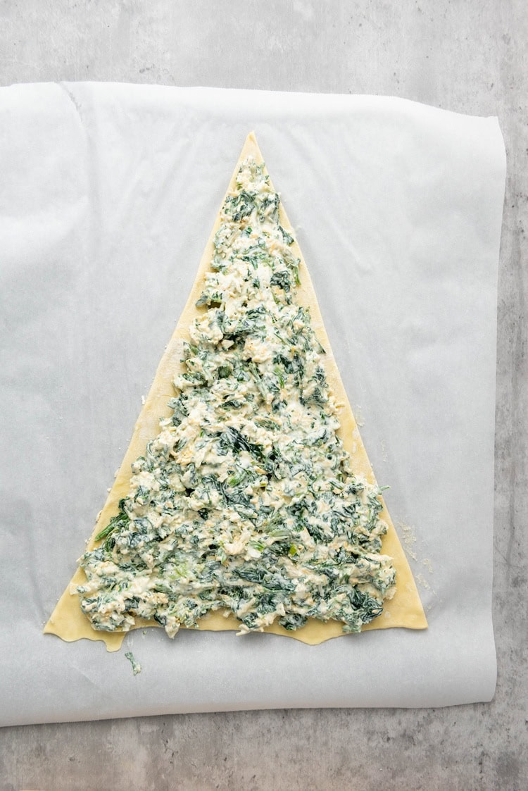 spinach dip evenly over the triangle
