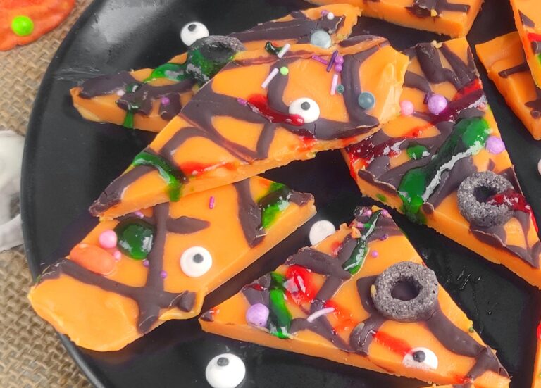 colorful white chocolate halloween bark on a black plate