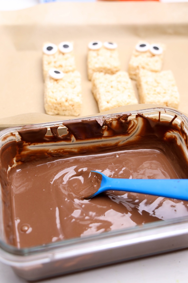 chocolate melted in a pan next to rice krispy treats