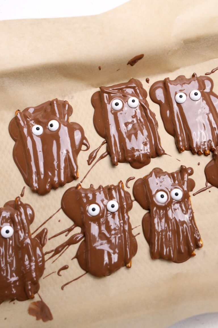 melted chocolate spooned over the pretzel sticks