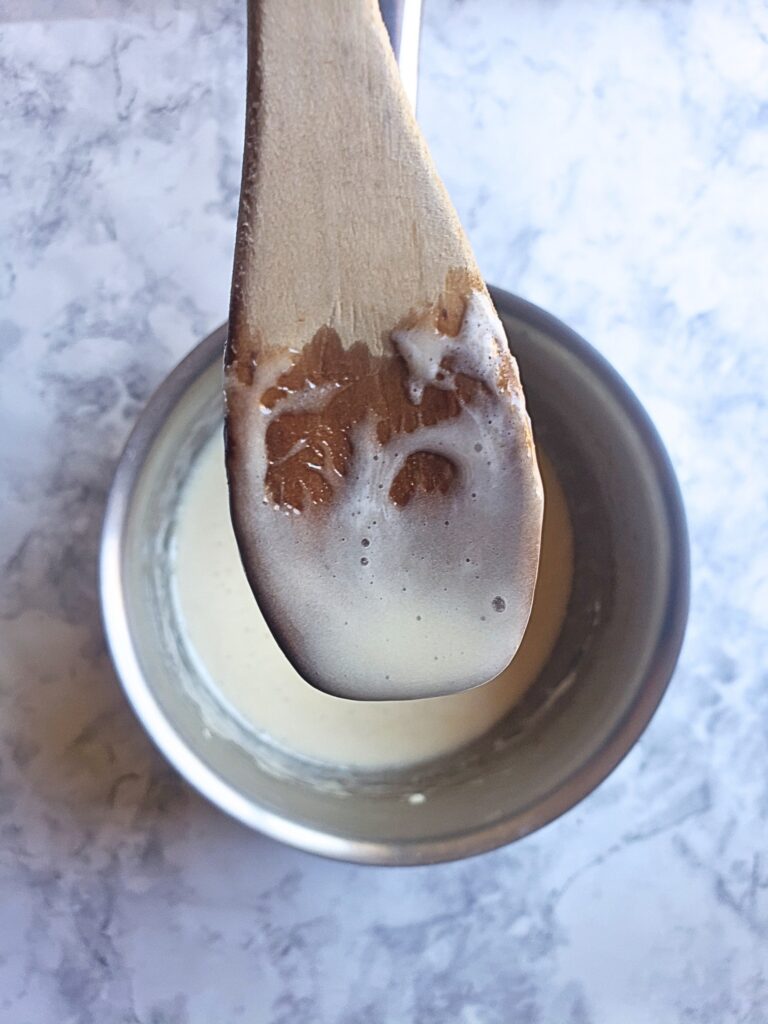 smoothly stirred marshmallows and butter and a close up of the mixture on a wooden spoon