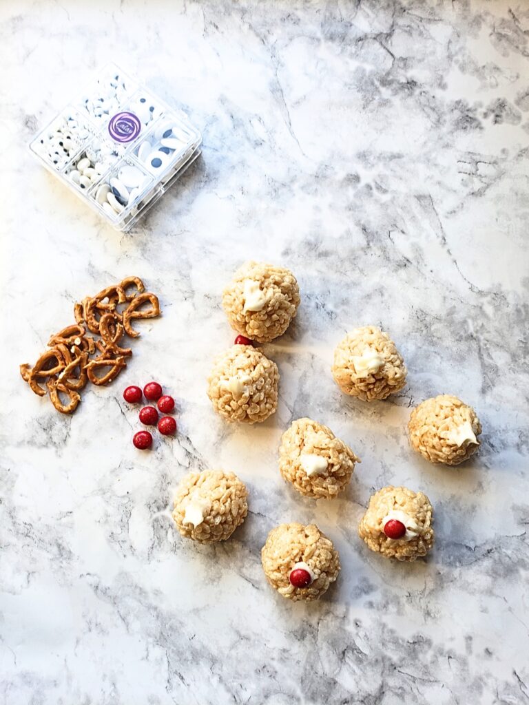 dab icing in the center of cereal balls and place red nose on top