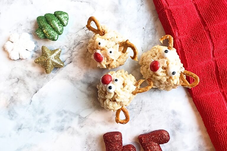 rice krispy reindeer treats on a marble table and red cloth with christmas decor