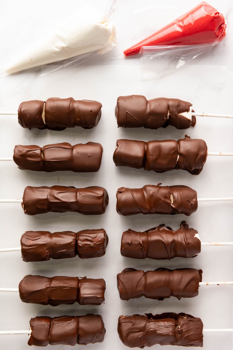 Lay the dipped pops on parchment paper and let them cool slightly before decorating