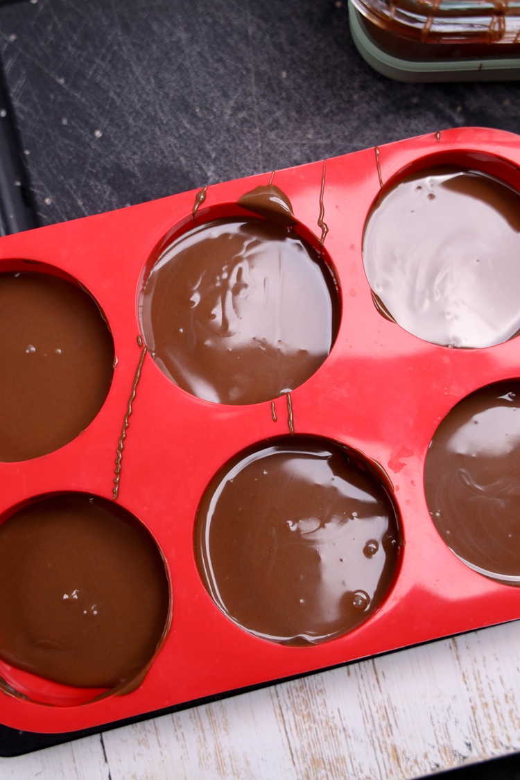 Spoon a small layer of melted chocolate into each cookie mold