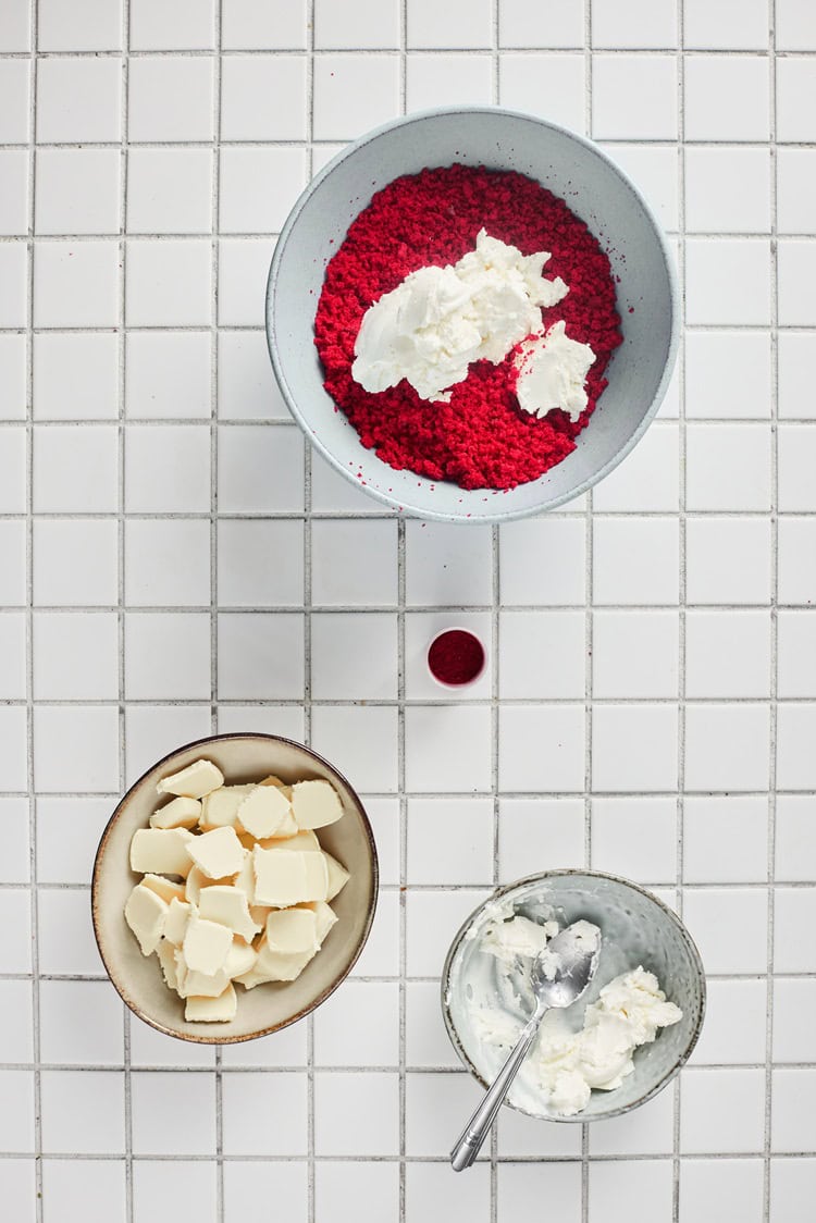 A picture of red velvvet crumbles being mixed with cream cheese frosting.