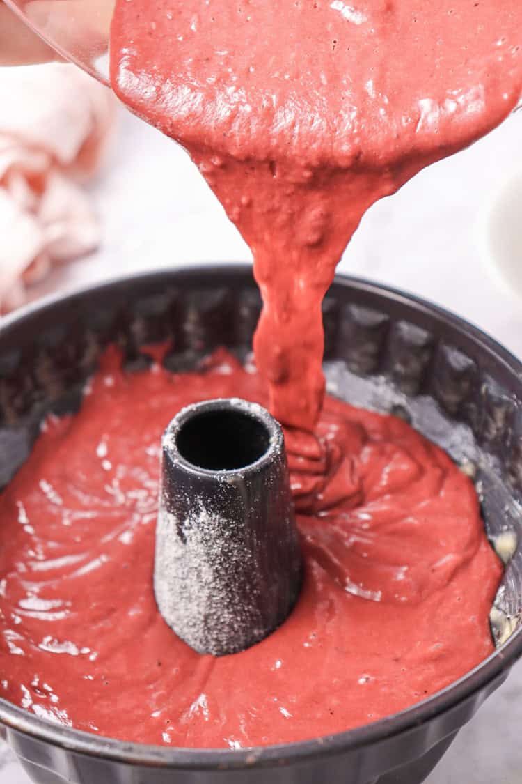 A picture of cake batter being poured into a bundt pan.