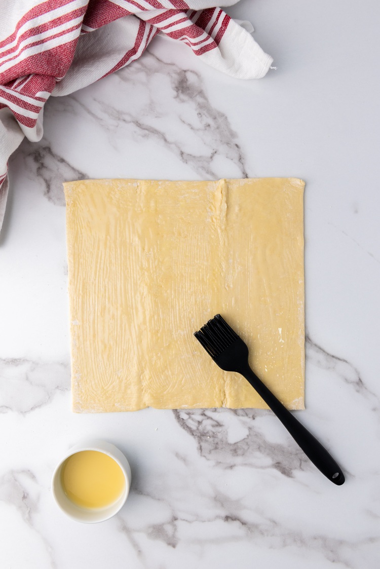 A picture of puff pastry sheets brushed with butter.