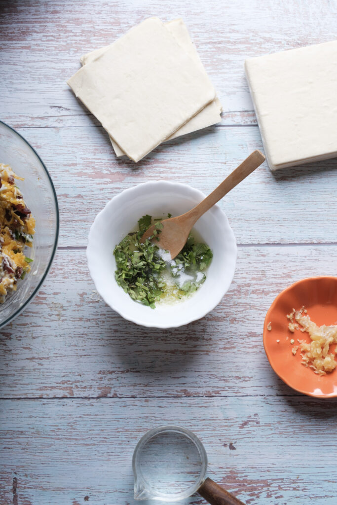 A picture of melted butter, chopped garlic, cilantro, and salt in a bowl.