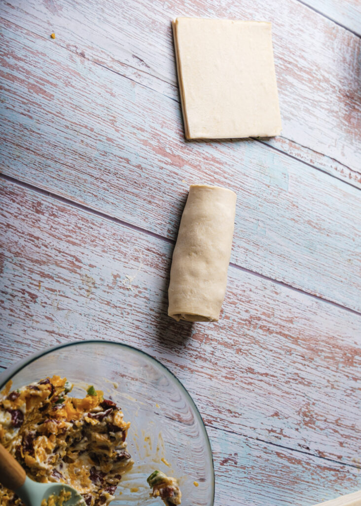 A pictur of a puff pastry with filling rolled into a log shape.