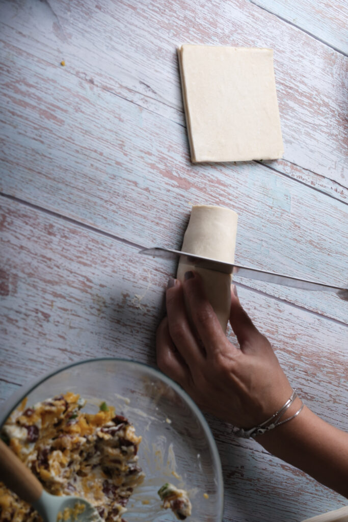 A picture of a filled puff pastry being cut in half.