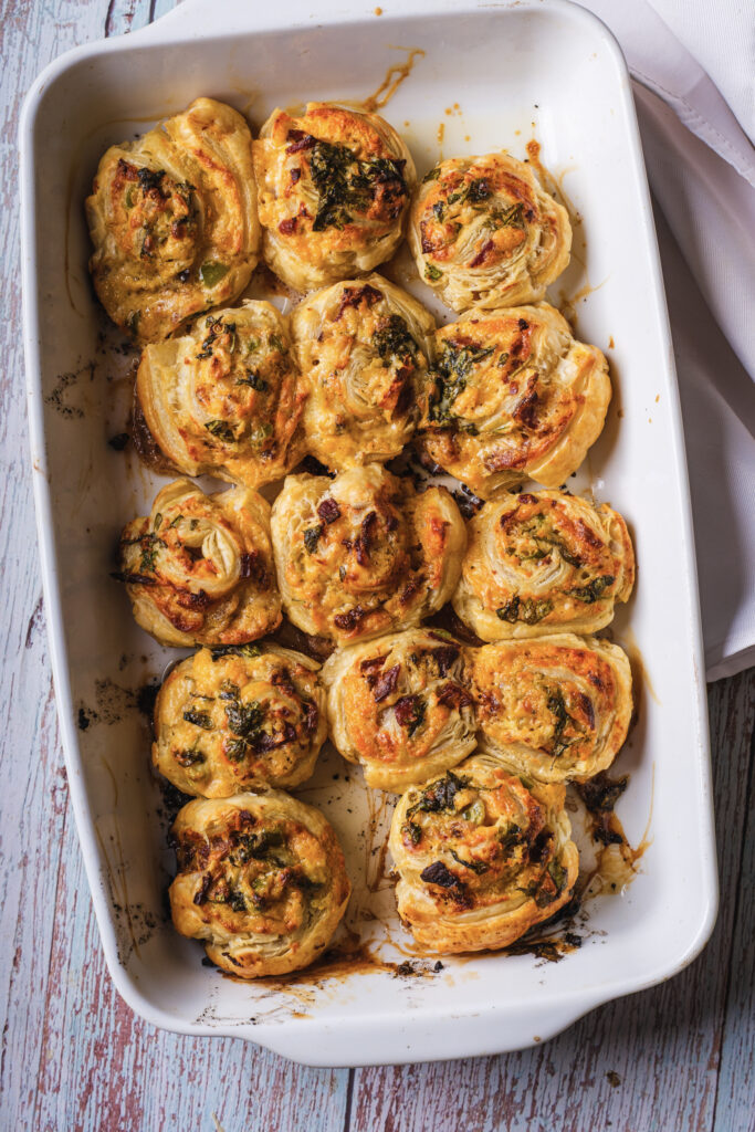 A picture of fully baked jalapeño popper pinwheels in a baking pan.