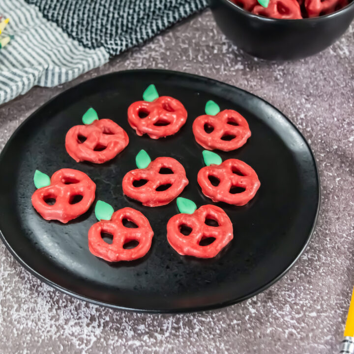 A picture of a tray of candy coated pretzels decorated to resemble apples.