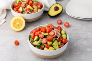 A picture of two servings of avocado salad in white bowls.