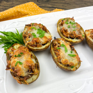 A picture of potato skins stuffed with chicken, cheese, and onions.