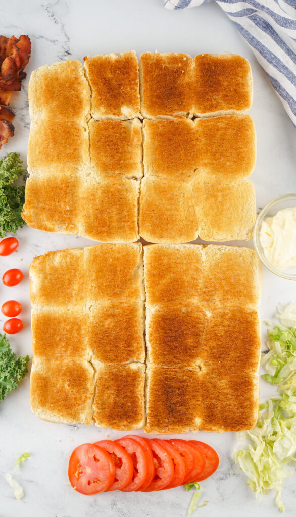 A picture of toasted sliced slider buns cut in half.