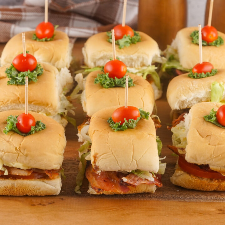 A picture of three columns of blt slider sandwiches topped with cherry tomatoes.