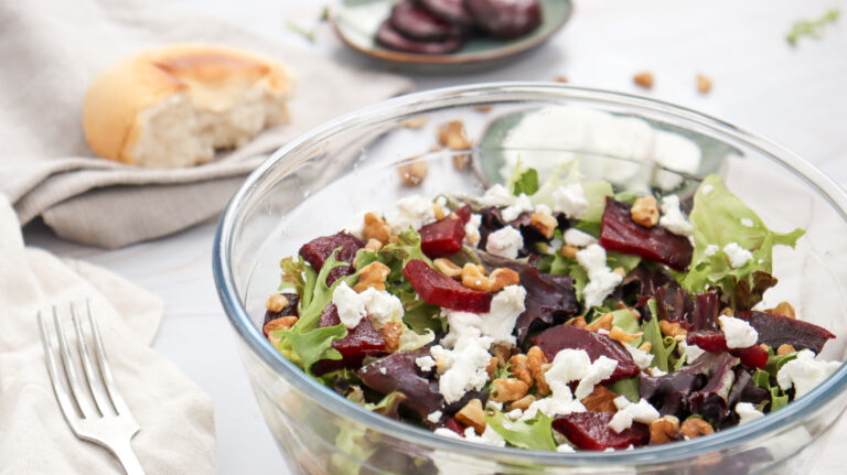 A picture of a beet and goat cheese salad in a glass serving bowl.