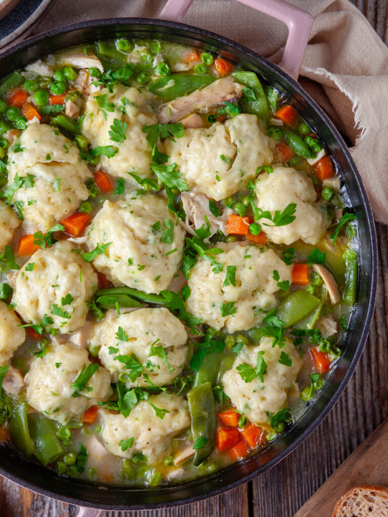 A picture of chicken dumplings with soup arrayed in a pot.