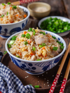 A picture of two bowls of chicken fried rice.