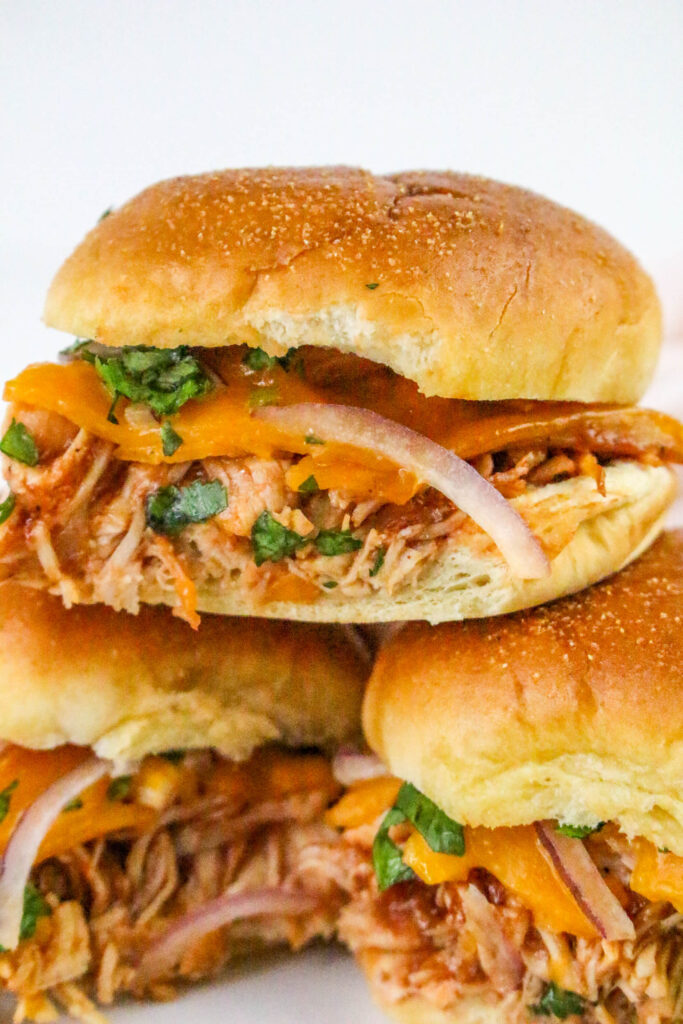 A close up picture of stacked chicken sliders, focused on the slider on top.