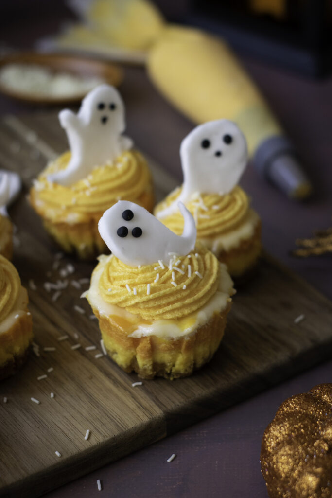 A picture of halloween mini cheesecakes all topped by sugar paste ghosts.