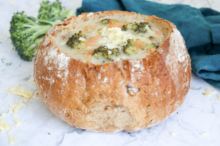 A picture of broccoli cheddar soup in a bread bowl.
