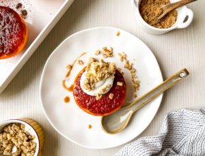 A close overhead picture of broiled pink grapefruit topped with greek yogurt and granola.