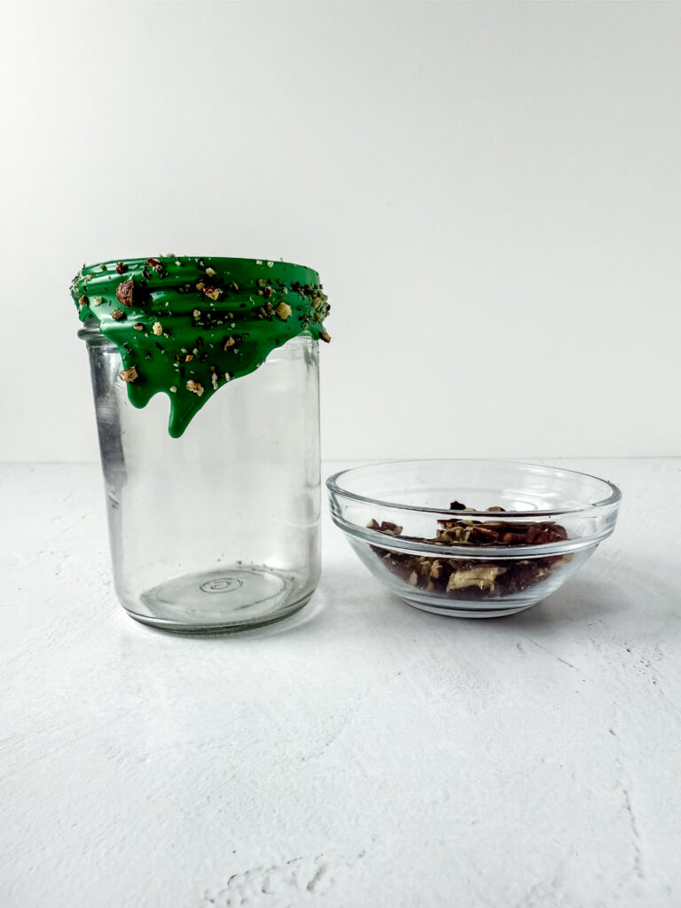 A picture of a jar with green frosting and pecans lining the lid.