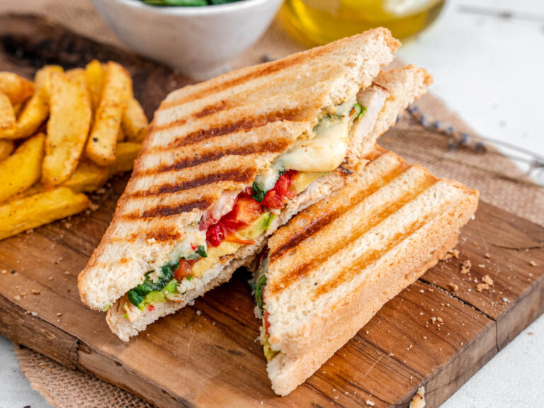 A picture of a chicken avocado panini, cut in half and stacked.