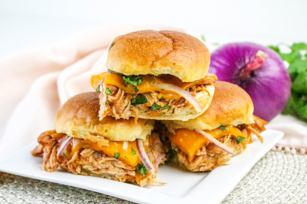 A picture of three chicken sliders with one slider stacked on top of the other two.