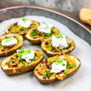 A picture of two rows of loaded baked potato skins arranged beautifully.