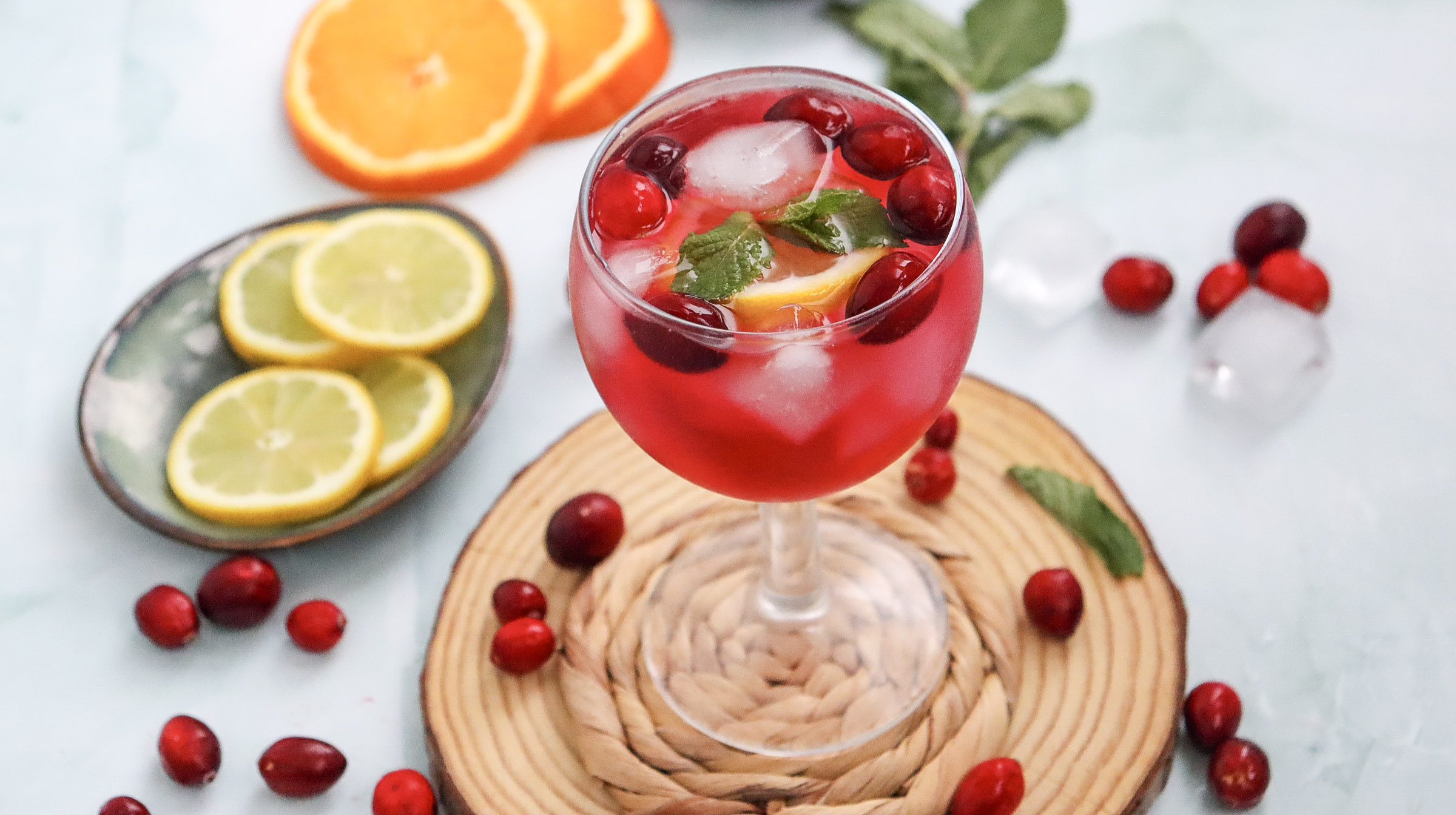 A picture of a cranberry spritzer mocktail in a wine glass.