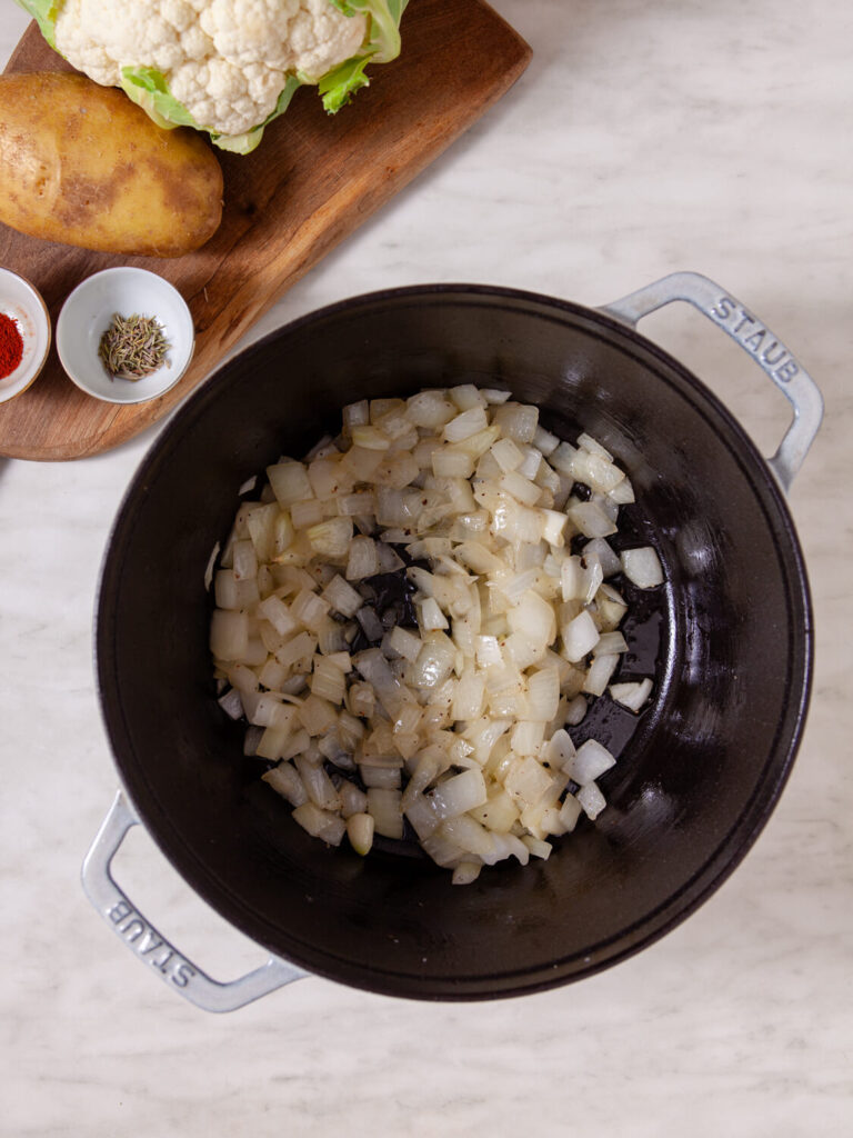 A picture of onions and garlic cooking in a pot.